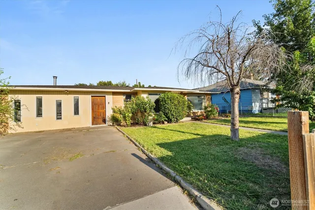 a view of a house with backyard and tree
