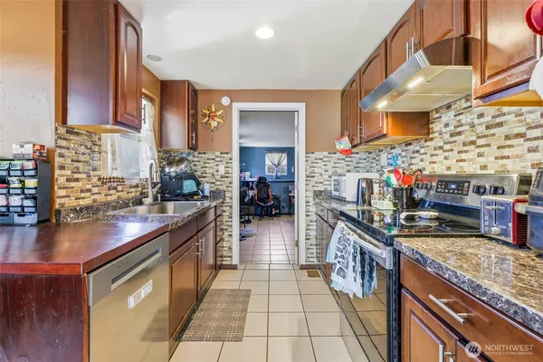 a kitchen with stainless steel appliances granite countertop a stove a sink and a wooden floors