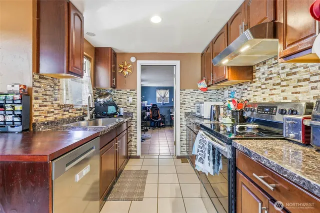 a kitchen with stainless steel appliances granite countertop a stove a sink and a wooden floors