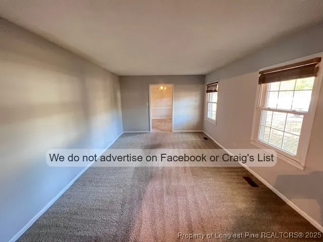 a view of a big room with wooden floor and windows