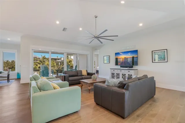 a large living room with stainless steel appliances a large window and a couch