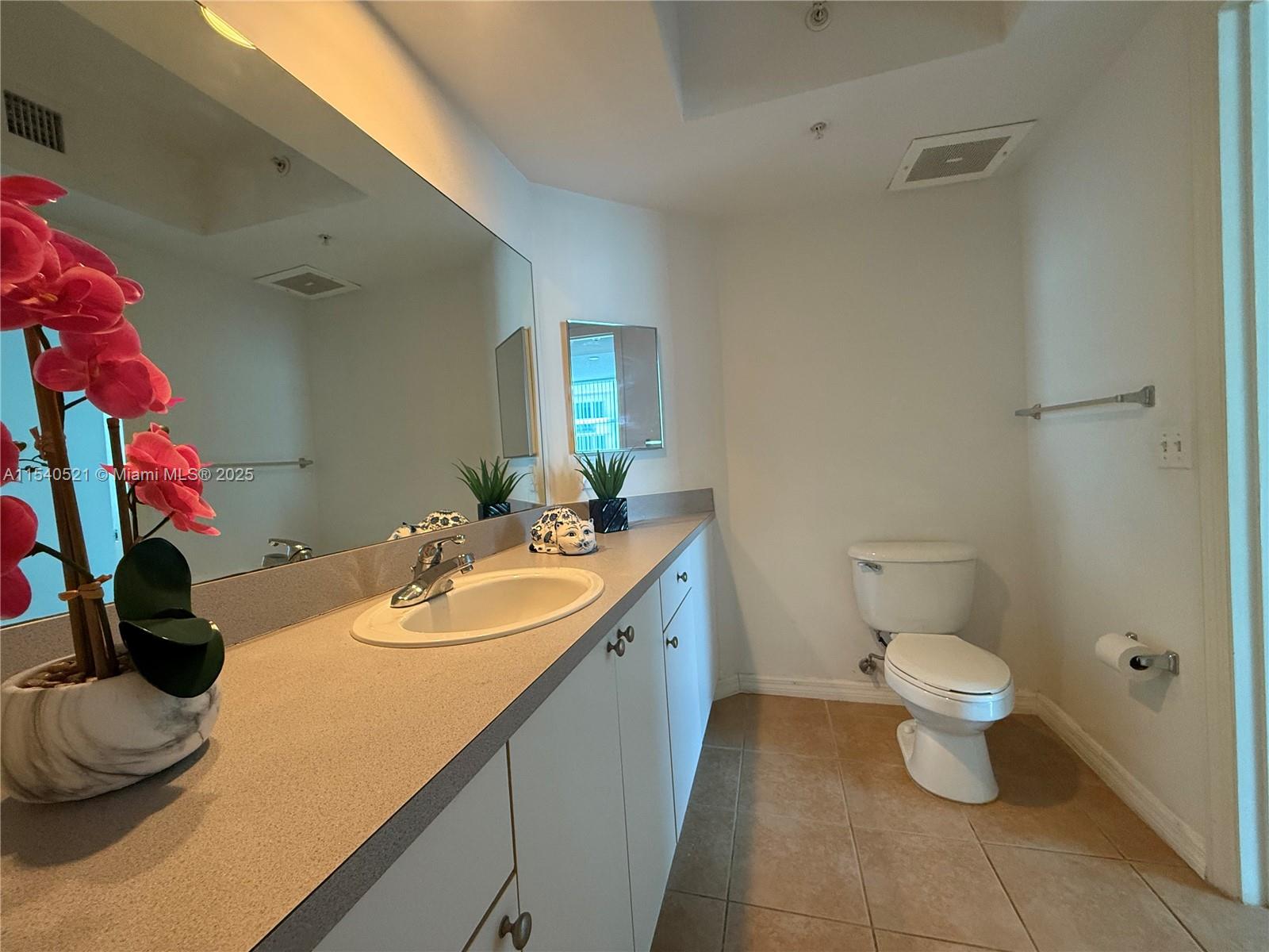 9201 Collins Avenue, Unit 1023 Surfside, FL 33154 - Photo 14 of 28 a bathroom with a sink toilet and a mirror