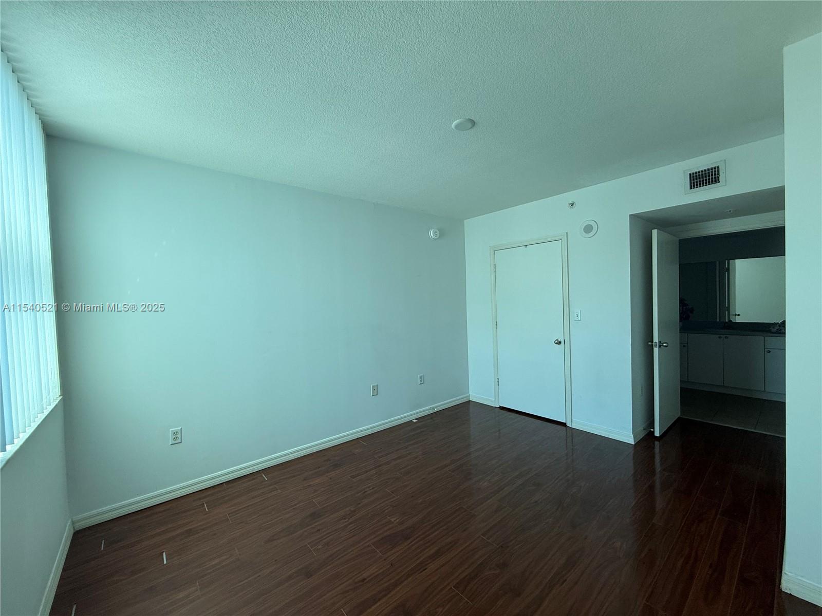 9201 Collins Avenue, Unit 1023 Surfside, FL 33154 - Photo 17 of 28 an empty room with wooden floor and closet