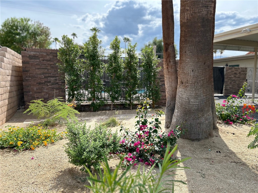 74443 Driftwood Drive, Unit 2 Palm Desert, CA 92260 - Photo 18 of 19 a view of a flower garden with a bench