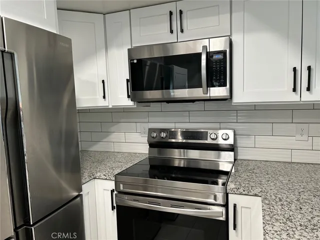 a kitchen with stainless steel appliances a stove a microwave and a sink
