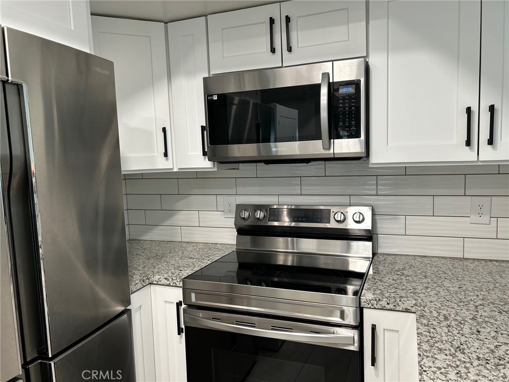 74443 Driftwood Drive, Unit 2 Palm Desert, CA 92260 - Photo 4 of 19 a kitchen with stainless steel appliances a stove a microwave and a sink