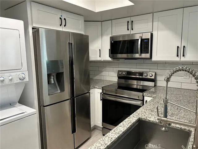 a kitchen with stainless steel appliances a refrigerator a stove and cabinets