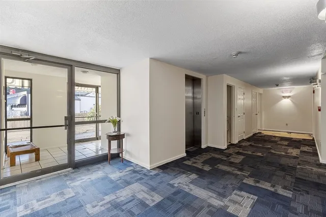 a view of a brick house with large windows and a tree