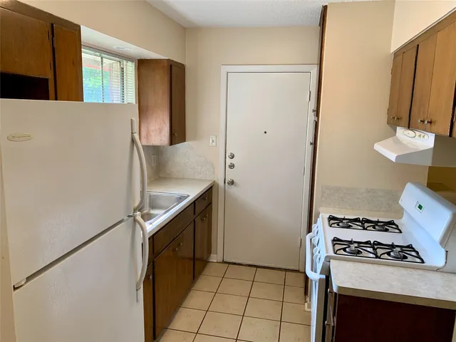 a kitchen with a stove cabinets and a refrigerator