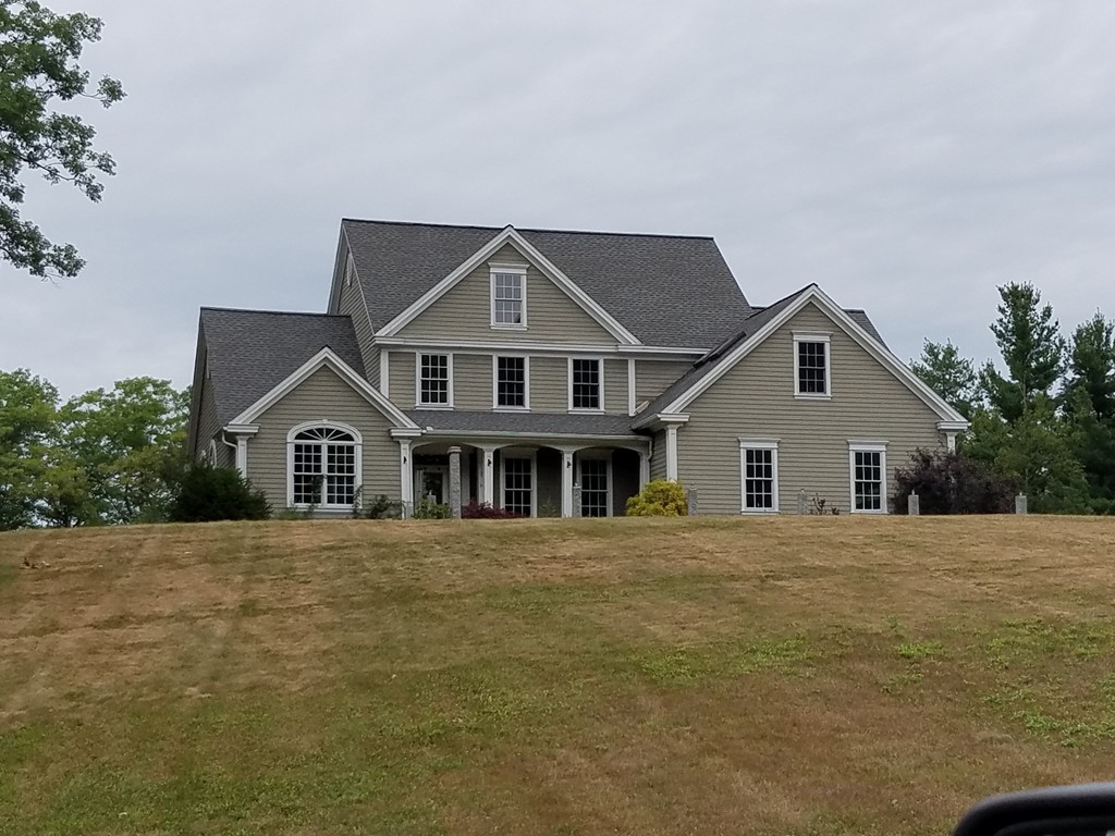 a front view of a house with a yard and trees