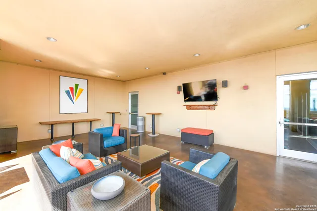a dining room with furniture large windows and a chandelier