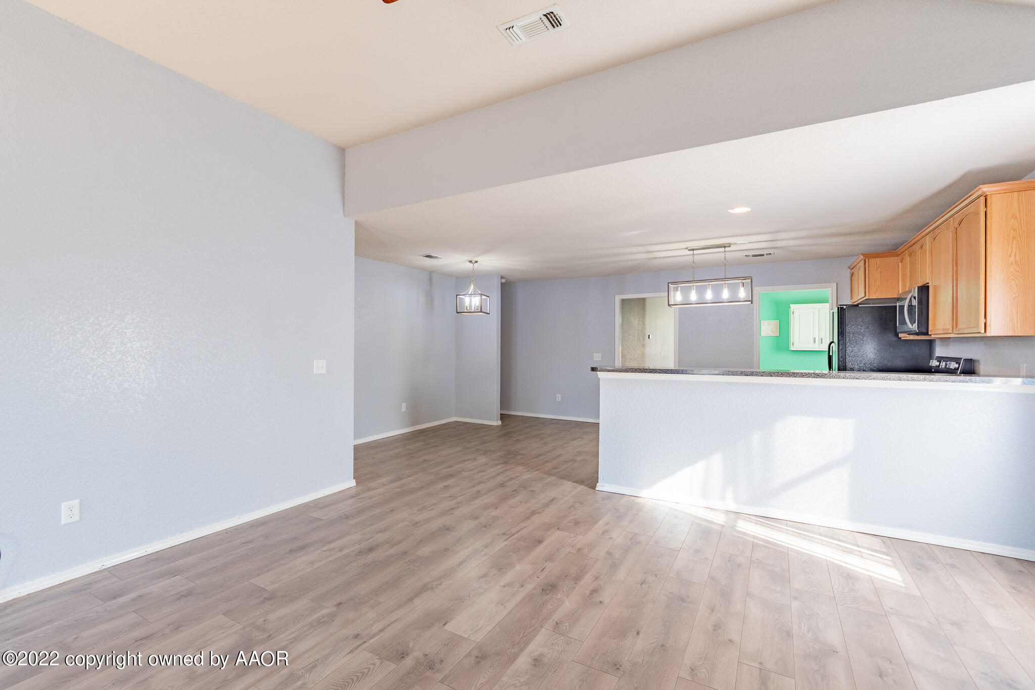4726 Capulin Lane Amarillo, TX 79110 - Photo 21 of 28 a view of kitchen and empty room with wooden floor