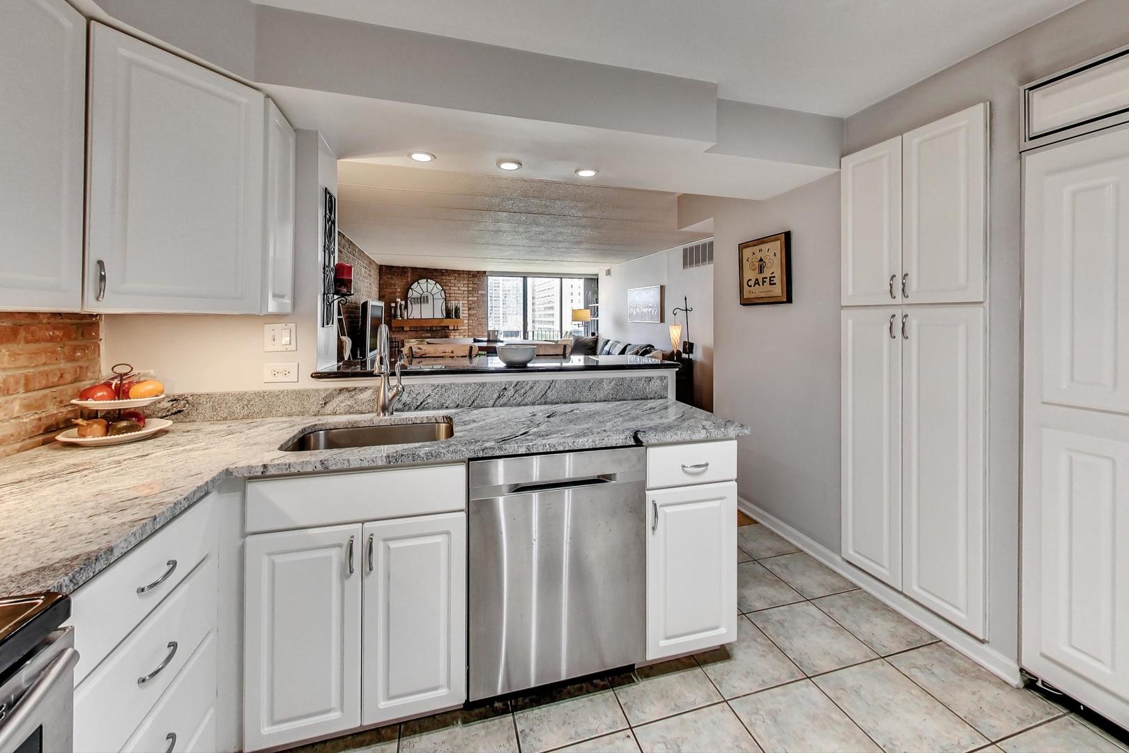 651 West Sheridan Road, Unit 7C Chicago, IL 60613 - Photo 11 of 27 a kitchen with stainless steel appliances granite countertop a sink and cabinets