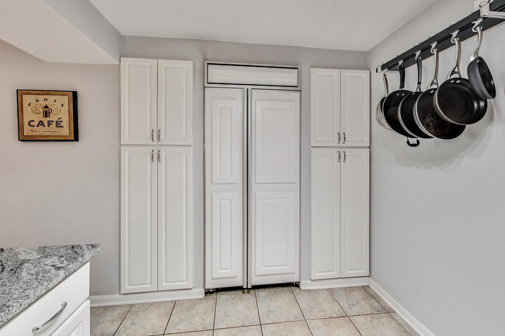 651 West Sheridan Road, Unit 7C Chicago, IL 60613 - Photo 12 of 27 a bathroom with a granite countertop sink and a washing machine with white cabinet