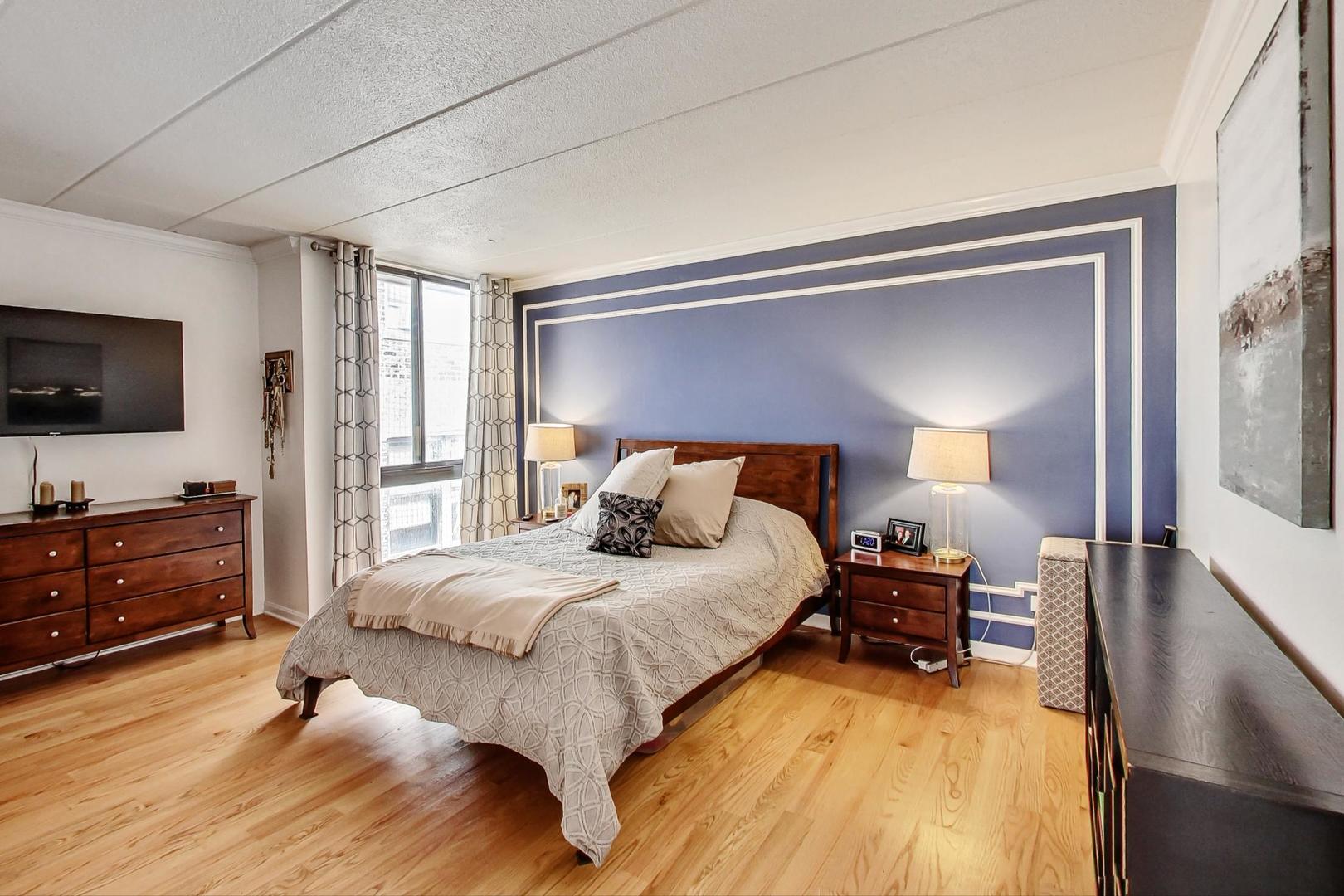 651 West Sheridan Road, Unit 7C Chicago, IL 60613 - Photo 13 of 27 a bedroom with a bed and a flat tv screen on dresser