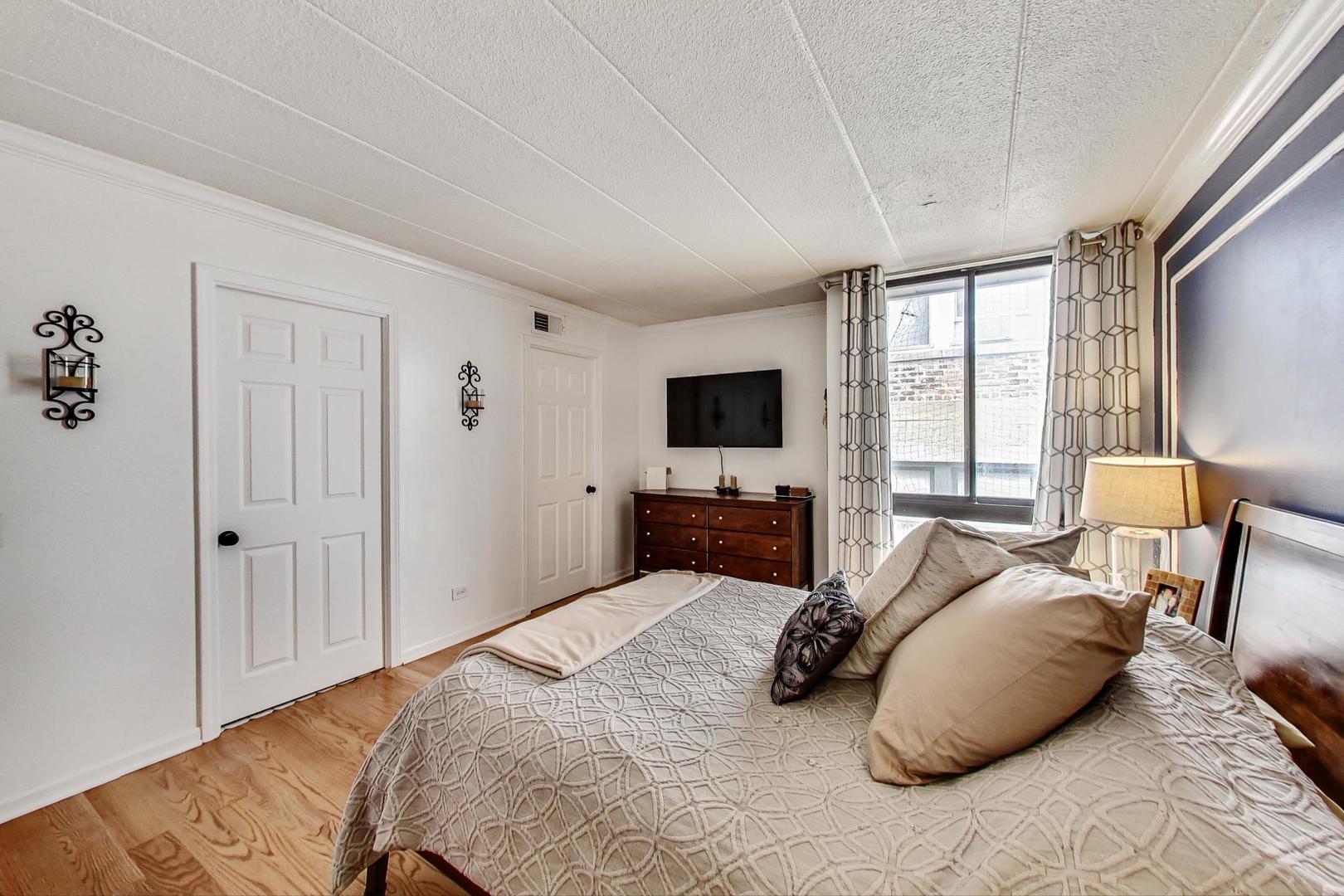 651 West Sheridan Road, Unit 7C Chicago, IL 60613 - Photo 14 of 27 a bedroom with a bed and a flat screen tv