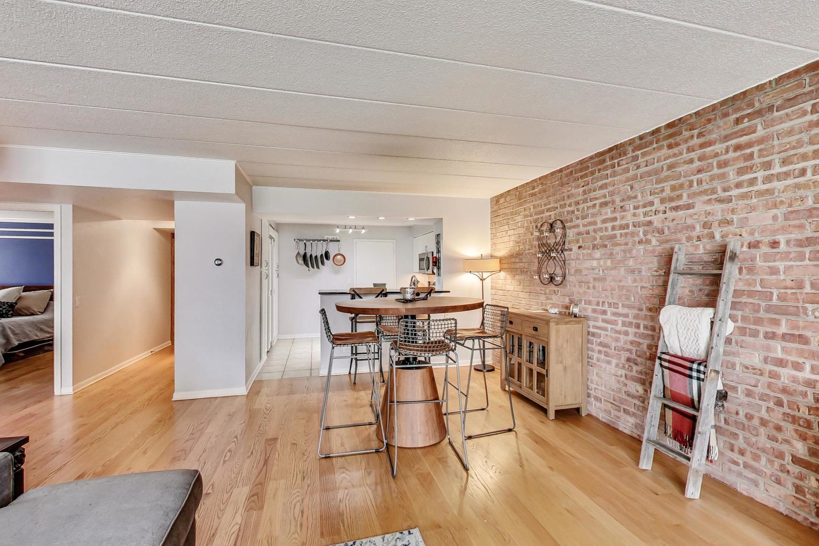 651 West Sheridan Road, Unit 7C Chicago, IL 60613 - Photo 8 of 27 a dining room with furniture and wooden floor