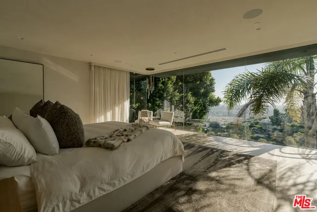 a bedroom with a bed and a large window