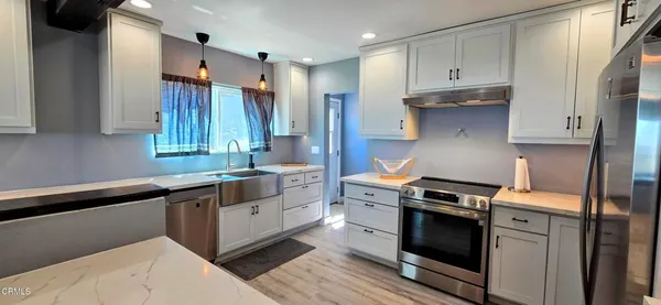 a kitchen with white cabinets and appliances
