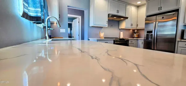a kitchen with stainless steel appliances kitchen island a refrigerator sink and cabinets