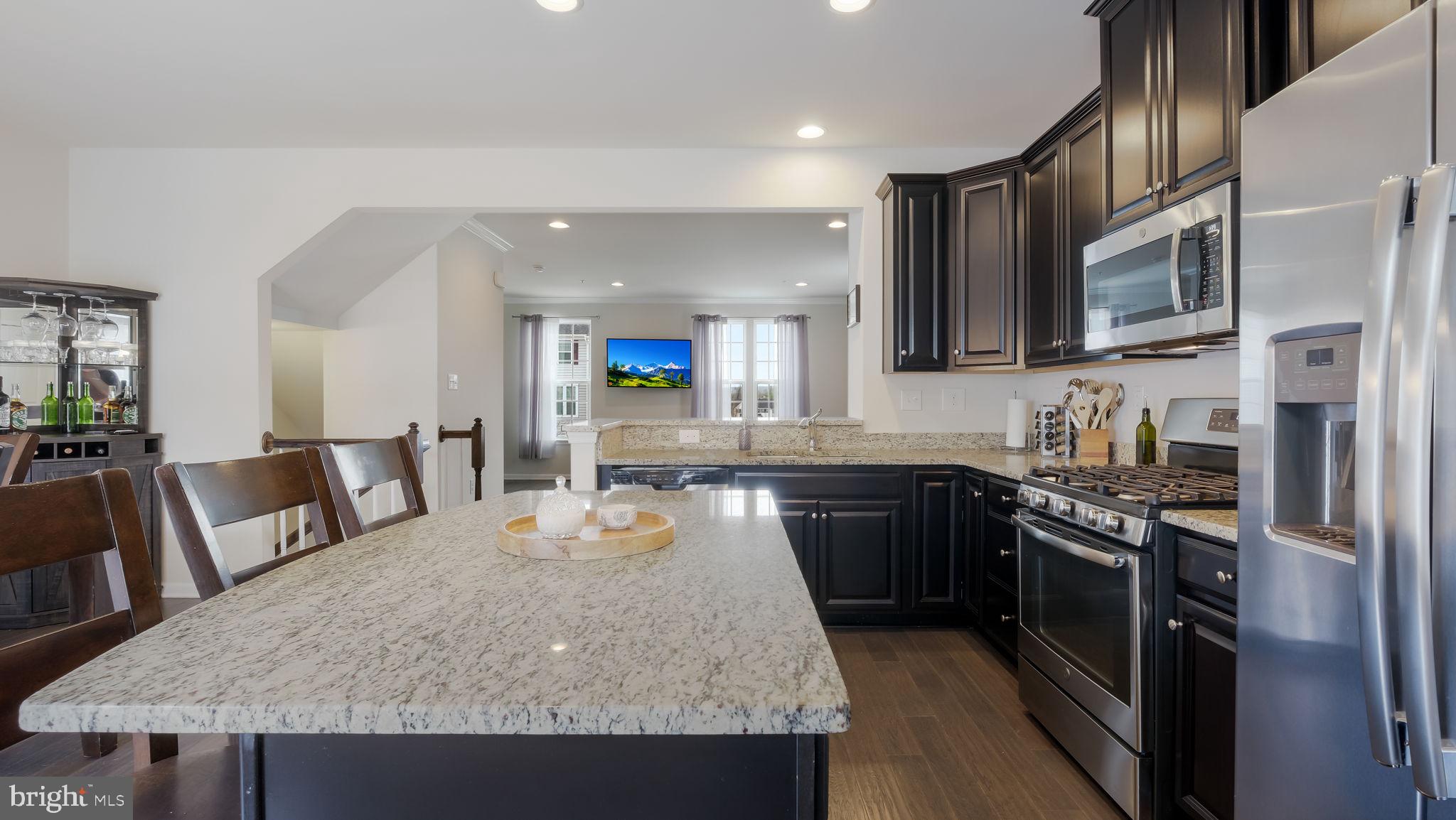 235 Ashburn Road Phoenixville, PA 19460 - Photo 16 of 31 a kitchen with stainless steel appliances granite countertop a stove top oven a sink a dining table and chairs