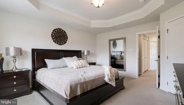 a bedroom with a bed and a lamp on dresser