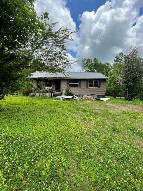 a view of a house with a big yard and potted plants