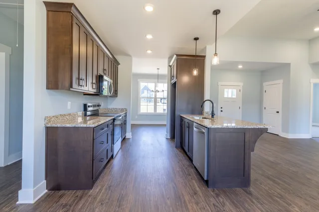 an empty room with wooden floor fireplace and windows