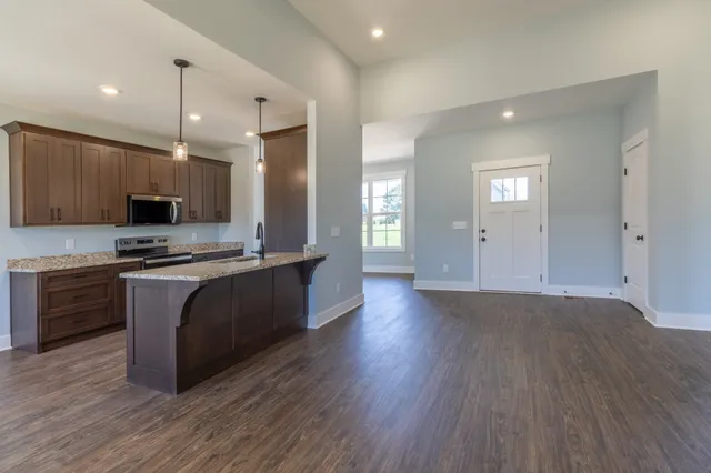 a kitchen with kitchen island a sink stainless steel appliances and cabinets