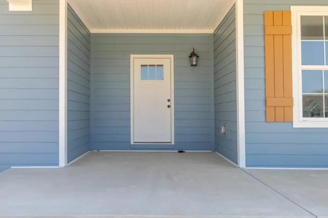 an empty room with wooden floor fireplace and windows