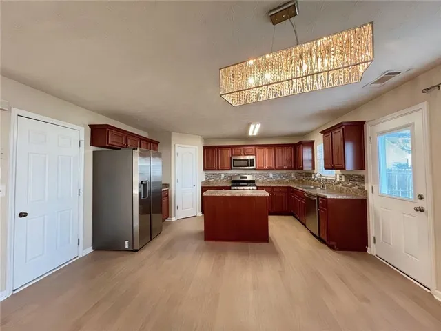 a kitchen with granite countertop wooden cabinets a stove top oven and granite counter tops