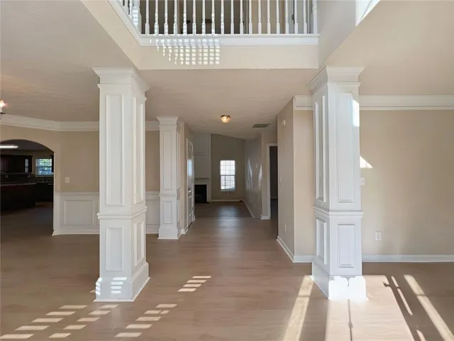 a view of a hallway with wooden floor and staircase