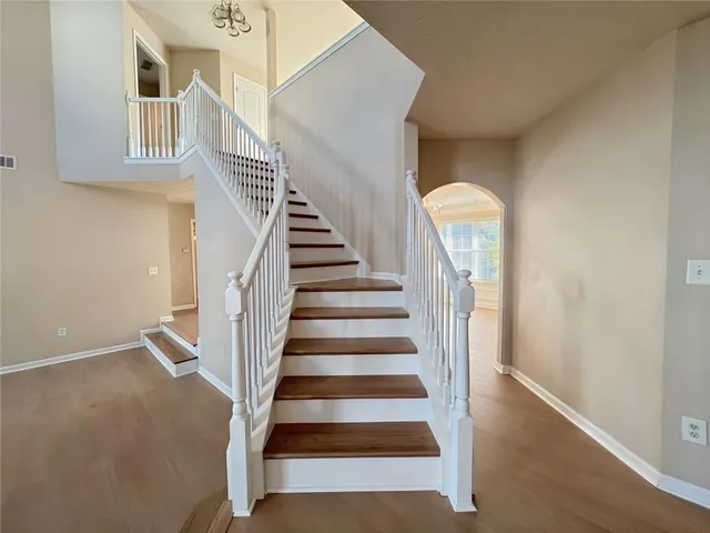 a view of a hallway with wooden floor and windows