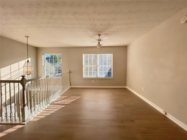 a view of a livingroom with a ceiling fan and wooden floor