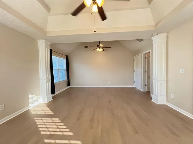 an empty room with a window and a ceiling fan