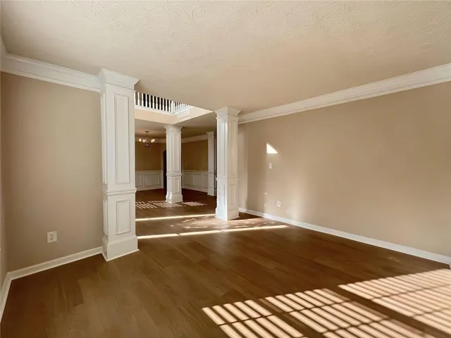 an empty room with windows and fireplace
