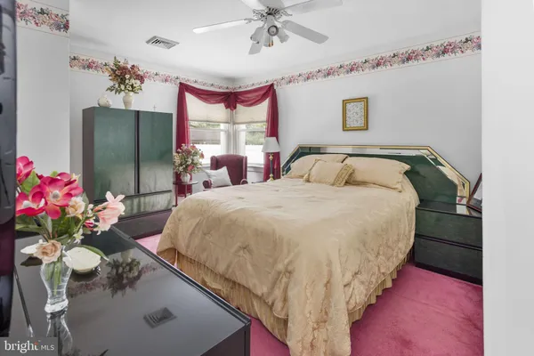 a bed room with a bed mirror and a chandelier