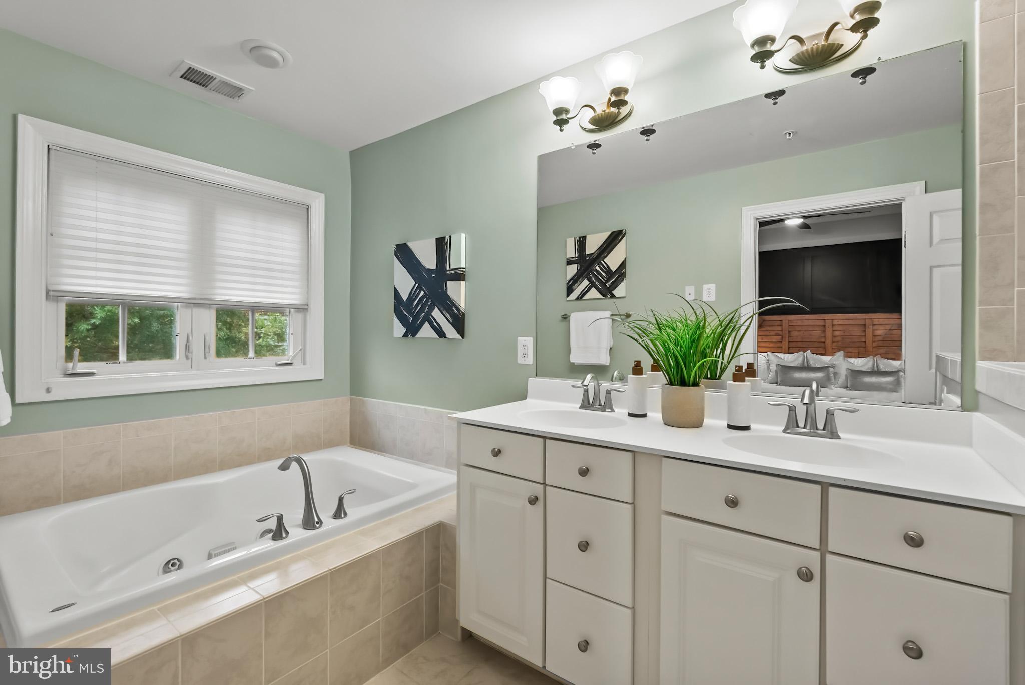 904 West Glebe Road Alexandria, VA 22305 - Photo 19 of 38 a bathroom with a tub a sink double vanity and a mirror