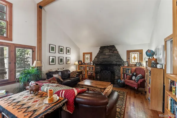 a kitchen with stainless steel appliances granite countertop a refrigerator a stove and a sink with wooden floor