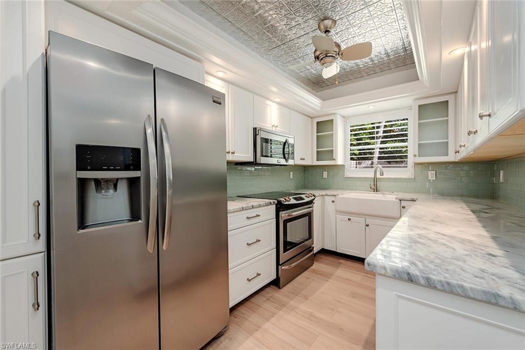185 4th Street South Naples, FL 34102 - Photo 11 of 22 a kitchen with granite countertop stainless steel appliances a stove refrigerator and cabinets