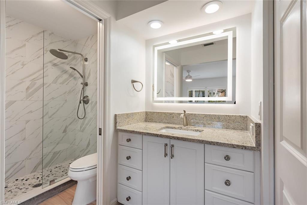 185 4th Street South Naples, FL 34102 - Photo 16 of 22 a bathroom with a granite countertop sink toilet and shower