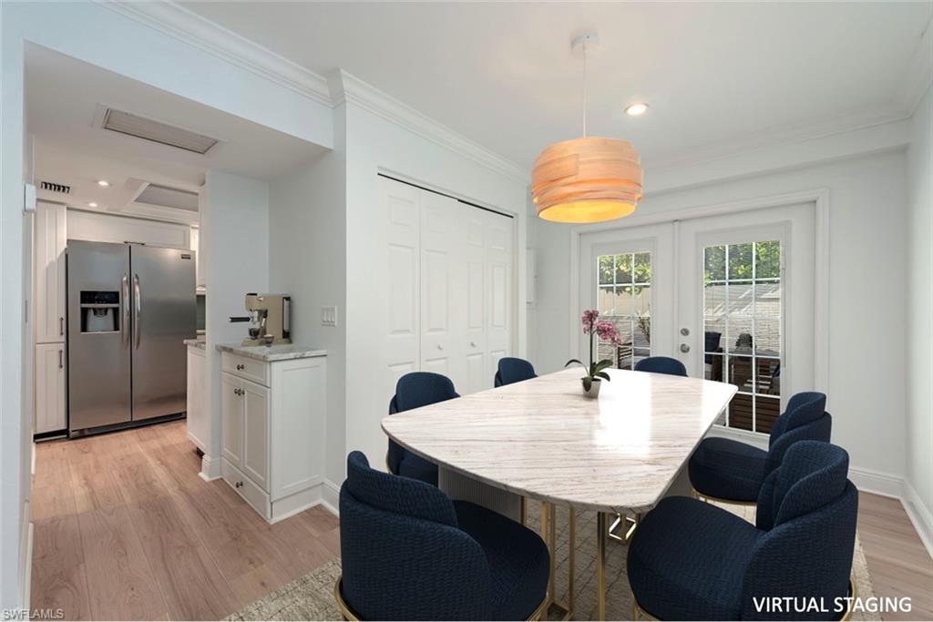 185 4th Street South Naples, FL 34102 - Photo 10 of 22 a kitchen with stainless steel appliances kitchen island granite countertop a table chairs and a refrigerator