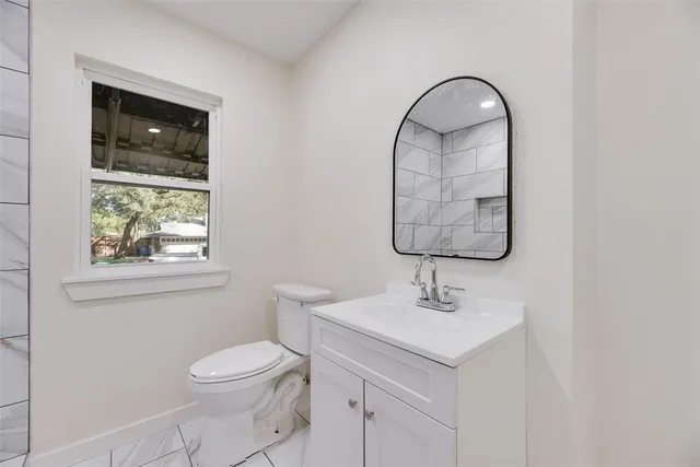 a bathroom with a sink toilet and a mirror