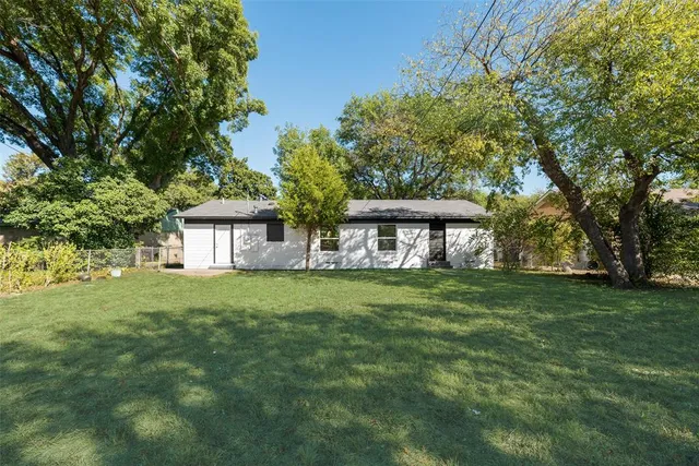 a view of a big yard with a house in the background