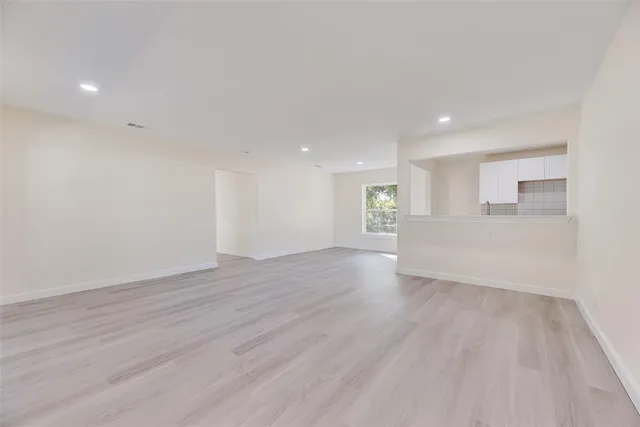 a view of a livingroom with wooden floor and staircase