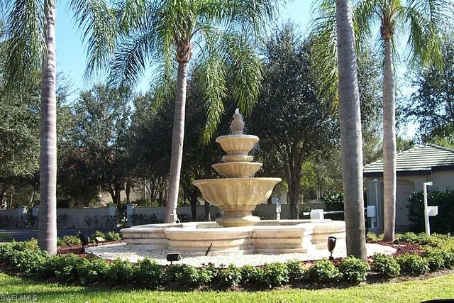 a front view of a house with garden and trees
