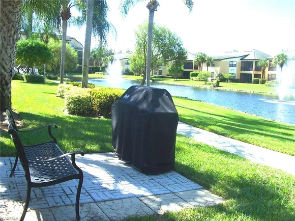 a view of a swimming pool and lounge chairs in back yard of the house