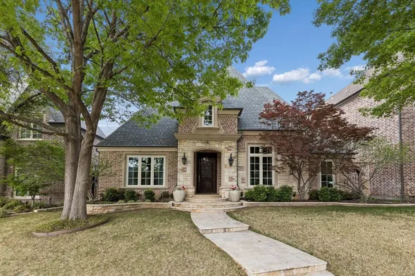 front view of a house with a yard and trees