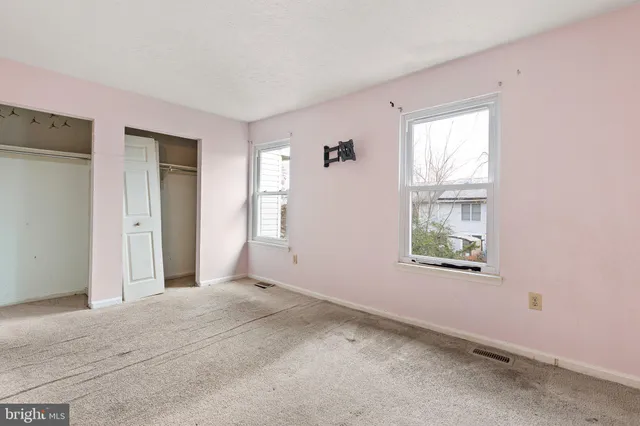 an empty room with windows and closet