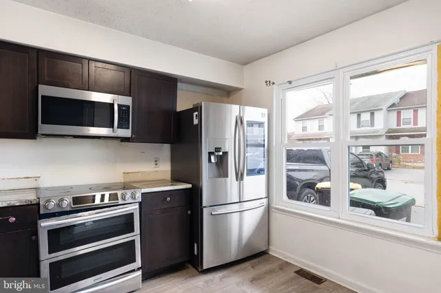 a kitchen with stainless steel appliances a stove a microwave and a refrigerator